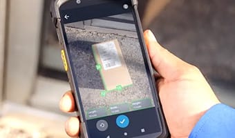 Entorno industrial con trabajadores utilizando computadoras móviles resistentes Zebra MC9300, impresoras ZT400 y lectores DS3608 en condiciones adversas de almacenamiento